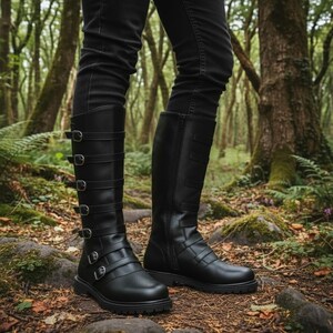 Puede incluir: Botas negras hasta la rodilla con m&uacute;ltiples correas con hebillas y cremallera lateral. Las botas tienen punta redondeada y suela gruesa. Las botas son de material liso.
