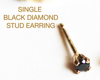 May include: A single black diamond stud earring in a gold setting. The earring is on a white background.