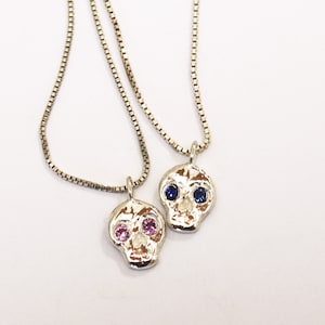 Skull friend charm with sapphire eyes