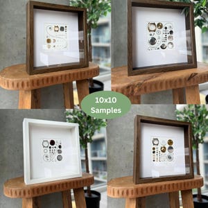 Puede incluir: Cuatro obras de arte enmarcadas, cada una con una disposici&oacute;n &uacute;nica de piezas de reloj sobre un fondo blanco. Los marcos son de color marr&oacute;n oscuro o blanco. El texto "10x10 Samples" es visible.
