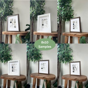 Puede incluir: Muestras de arte enmarcadas, cada una de 20x25 cm, se exhiben en peque&ntilde;os taburetes de madera. Los marcos son blancos o marrones, y la obra de arte presenta una colecci&oacute;n de formas circulares y geom&eacute;tricas en blanco y negro.