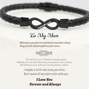 May include: Black braided leather bracelet with a black infinity charm. The charm is engraved with the names "Sophia" and "Lucas". The text "Lo My Man" and a romantic message are also visible.
