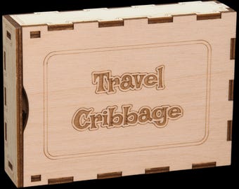 以下が含まれることがあります： 前面に「Travel Cribbage」と刻まれた木製の箱です。
