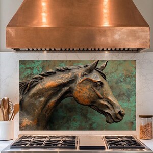 Könnte beinhalten: Eine kupferne Dunstabzugshaube mit einem Bronze-Pferdeskulpturen-Spritzschutz. Die Dunstabzugshaube hat eine Kupfer-Oberfläche und ein modernes Design. Der Spritzschutz ist aus strukturiertem Metall mit einer grün-blauen Patina.