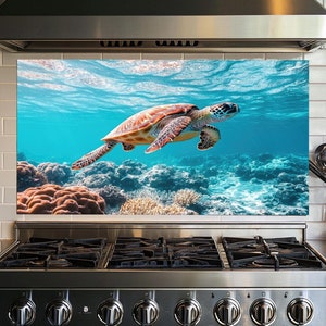 May include: A vibrant kitchen backsplash featuring a sea turtle swimming in clear blue water above a coral reef. The turtle has a brown and orange shell. The backsplash is installed above a stainless steel stove.