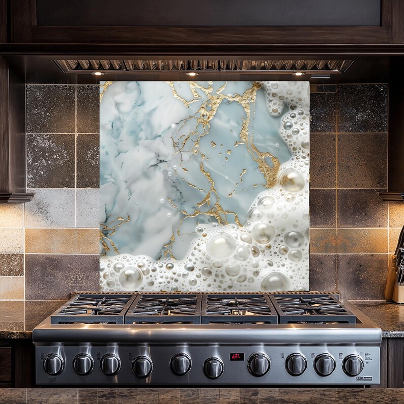May include: A kitchen backsplash with a marble and gold design. The marble is light blue and white with gold veins. The design is topped with a layer of white foam with bubbles.