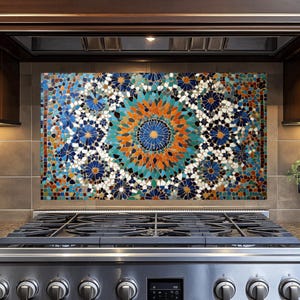 Puede incluir: Un salpicadero de azulejos de mosaico de colores con un patrón geométrico en tonos de azul, verde, naranja y blanco. El salpicadero está instalado sobre una estufa de acero inoxidable con una rejilla de quemador negra.