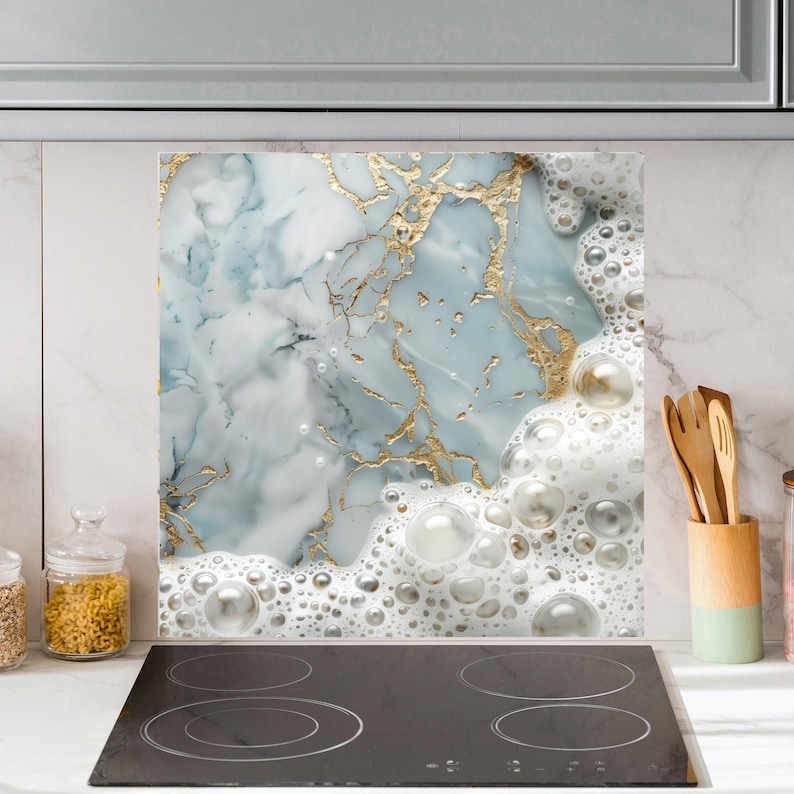 May include: A kitchen backsplash with a marble and gold design. The marble is light blue and white with gold veins. The design is topped with a layer of white foam with large bubbles.