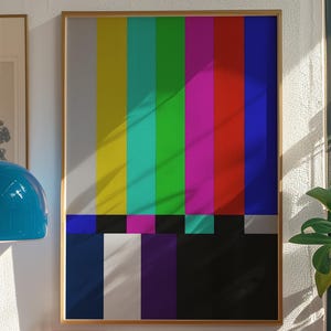 May include: A framed print with a vibrant test card design, showcasing vertical bands of colour including yellow, green, magenta, and red. The print hangs above a red shelf with a record player and other decorative items.