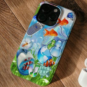 May include: A smartphone case with a colorful design featuring goldfish, a globe, and a retro cell phone. The case is on a wooden surface next to a white wireless earbud case.