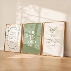 Può includere: Tre stampe artistiche incorniciate con citazioni ispiratrici. Le stampe hanno una cornice in legno. La prima stampa ha il testo "Every good & perfect gift is from above" con un bordo a pois. La seconda stampa dice "The Joy of the Lord is my strength". La terza stampa dice "I am fearfully & wonderfully made".