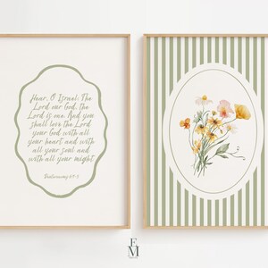 May include: Two framed art prints. The left print features text within a sage green, irregular shaped border. The right print has a floral bouquet in an oval frame against a green and white striped background. Both prints have a light wood frame.