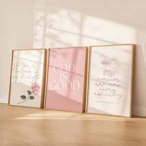 Könnte beinhalten: Drei gerahmte Kunstdrucke mit inspirierenden Zitaten. Der erste zeigt eine rosa Rosenillustration und den Text "die Freude des Herrn ist meine Stärke". Der zweite Druck ist rosa mit den Worten "GOD IS GOOD". Der dritte Druck hat eine Schleife und den Text "Seine Gnade ist jeden Morgen neu."