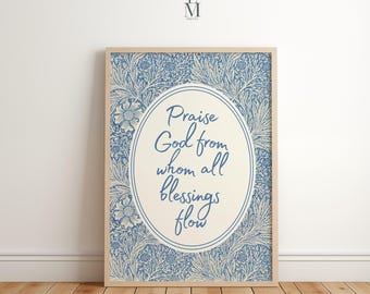 May include: A framed print featuring the text "Praise God from whom all blessings flow" in a blue script. The background has a blue floral pattern. The frame is a light wood color.