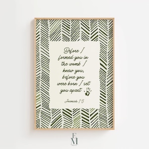 May include: A framed print with a light wood frame. The print features a cream-colored background with a quote in elegant script: "Before I formed you in the womb I knew you, before you were born I set you apart." The background has a green chevron pattern.