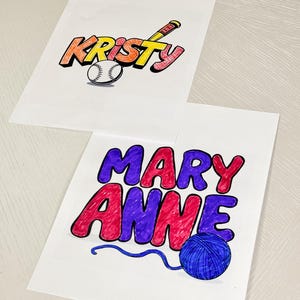 May include: Two personalised name signs, one with the name "Kristy" in yellow, orange, and red with a baseball and bat, and the other with the name "Mary Anne" in purple, red, and blue with a ball of yarn and a blue string.