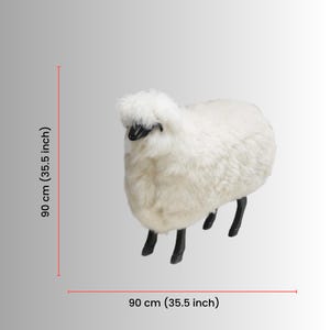 May include: A white sheep-shaped ottoman with black legs and a black face. The ottoman is 35.5 inches long and 35.5 inches wide, and 35.5 inches tall. The sheep has a fluffy, textured appearance.