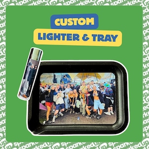 May include: A custom lighter and a rectangular rolling tray featuring a photographic print of a large group of people at an outdoor festival. The text CUSTOM LIGHTER & TRAY is displayed in yellow and blue against a green background with white text.