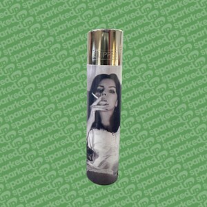 May include: A silver Clipper lighter featuring a black and white portrait of a woman smoking. The lighter has a metallic top and a black base. The image is printed on a paper sleeve wrapped around the lighter.