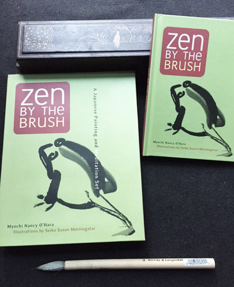 May include: Two books titled "Zen by the Brush" with green covers and abstract black ink illustrations. A wooden ink box and a calligraphy brush are also present. The books are by Myochi Nancy O'Hara, with illustrations by Seiko Susan Morningstar.