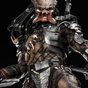 May include: A detailed, close-up of a Predator figure, showcasing intricate armor and a menacing facial expression. The figure features a brown and tan color scheme with metallic accents, sharp teeth, and dreadlocks. The background is black.