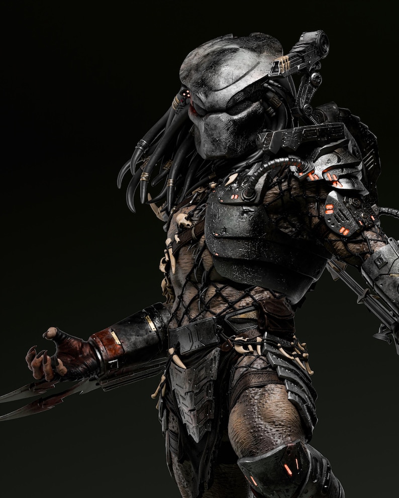 May include: A detailed, three-quarter view of a Predator figure. The figure is predominantly dark gray and black, with intricate armor and dreadlocks. The Predator's mask has a metallic sheen, and its claws are extended.