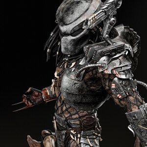 May include: A detailed, three-quarter view of a Predator figure. The figure is predominantly gray and black, with intricate armor plating and a bio-mask. The Predator's dreadlocks are black, and it has sharp claws extended. The figure is a collectible item.