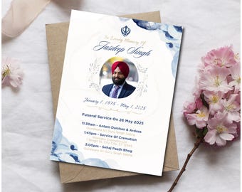 May include: A white funeral announcement card with blue watercolor accents and a gold border. The card features a photo of a man wearing a turban and a blue suit. The text reads "In Loving Memory of Jasdeep Singh" and includes the dates "January 1, 1975 - May 1, 2025". The card also includes details for the funeral service, including the date, time, and location.