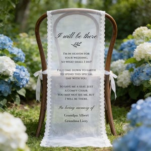 May include: A wooden chair adorned with a white fabric drape, edged with lace. The fabric displays printed text, including "I will be there" and a memorial message. The chair is positioned outdoors, surrounded by flowers.