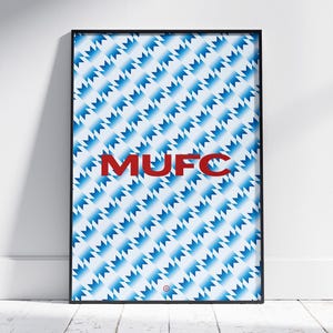 Peut inclure: Une impression encadrée avec un motif géométrique bleu et blanc et le texte "MUFC" en rouge.