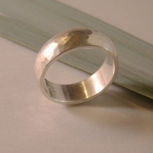 May include: A silver hammered band ring with a smooth, polished interior.