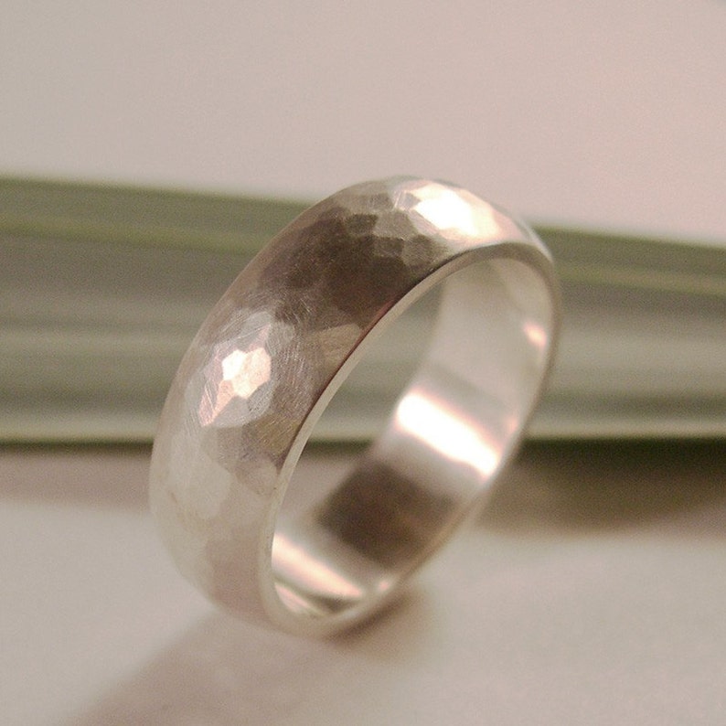 May include: A silver hammered wedding band with a smooth, polished interior.