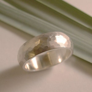 May include: A silver hammered wedding band with a smooth, polished interior.