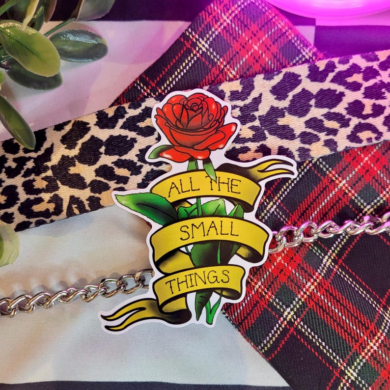 May include: A sticker with a red rose and a yellow banner that reads "All the small things".