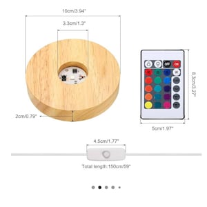 Può includere: Base luminosa a LED in legno, diametro 10 cm, con telecomando. Il telecomando ha opzioni di colore e controlli. La lunghezza totale del cavo è di 150 cm.