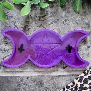 Peut inclure: Plat triple lune en résine violette avec un pentagramme au centre. Le plat a deux petites croix noires de chaque côté du pentagramme.