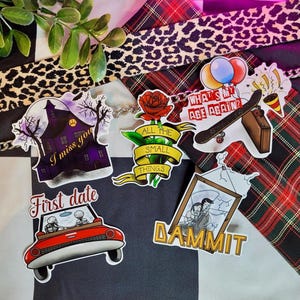 May include: A set of nine stickers featuring various designs, including a haunted house, a car with skeletons, a rose with the text "All the small things", a skateboard with the text "What's my age again?", and a picture frame with the text "Dammit".