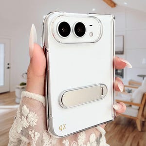 Peut inclure: Une coque de protection transparente pour smartphone pliable, dotée d'une découpe pour double appareil photo, d'un support horizontal argenté métallique au dos et des lettres QZ dorées imprimées dans le coin inférieur gauche.