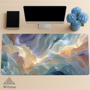 May include: A rectangular desk mat with a flowing, abstract design in shades of blue, cream, and gold. The mat features a textured, cloud-like pattern. The word "Witosa" is printed at the bottom. A black book, computer monitor, and blue flowers are on the desk.