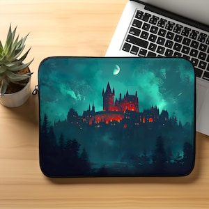 Puede incluir: Una funda para portátil con un fondo azul oscuro que presenta una silueta de un castillo con ventanas brillantes contra un cielo tormentoso con una luna creciente.