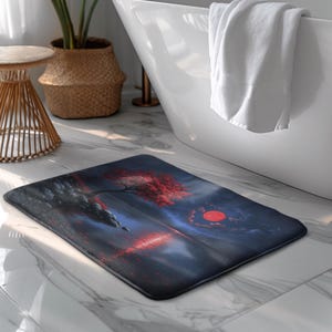 Peut inclure: Tapis de bain rectangulaire avec un paysage serein. Il présente un arbre aux feuilles rouges, un grand soleil rouge et un plan d'eau, sur un fond bleu foncé et noir. Le tapis est posé sur un sol en carrelage de marbre.