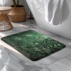 Può includere: Un tappetino da bagno rettangolare verde con un design floreale dettagliato in tonalità di verde e oro. Il tappetino presenta uno sfondo strutturato ed è posizionato su un pavimento di marmo vicino a una vasca da bagno bianca.