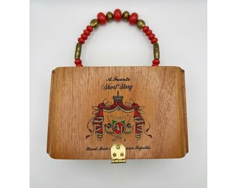 Bolso de mano con asa de cuentas y diseño de caja de puros de Arturo Fuente.