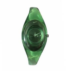 May include: A green Nike watch with a transparent band. The watch face is circular with white hands and a small Nike logo. The band is a solid, curved design.