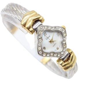 Puede incluir: Reloj de cuarzo plateado y dorado con esfera cuadrada. La esfera es blanca con agujas doradas y la marca "Colezin". La correa tiene un diseño de cable trenzado.