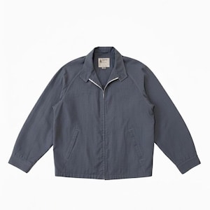 Könnte beinhalten: Eine schieferblaue Jacke mit weißem Reißverschluss und Kragen. Die Jacke hat zwei Vordertaschen und ein kleines Etikett in der Nähe des Kragens. Die Ärmel sind lang und die Jacke ist aus leichtem Material gefertigt.