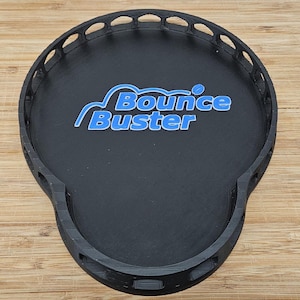May include: Black plastic tray with a raised edge and a decorative border. The tray has a blue logo that says "Bounce Buster" with a stylized mountain design.