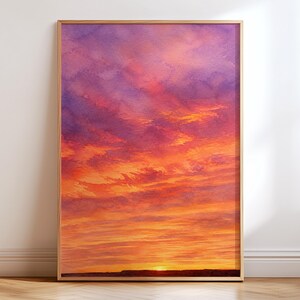 Pode incluir: Uma impressão de arte de parede retangular emoldurada apresentando um céu vibrante ao pôr do sol com formações de nuvens horizontais. A paleta de cores transita do roxo profundo e magenta no topo para tons de laranja e amarelo brilhantes perto da linha escura do horizonte.