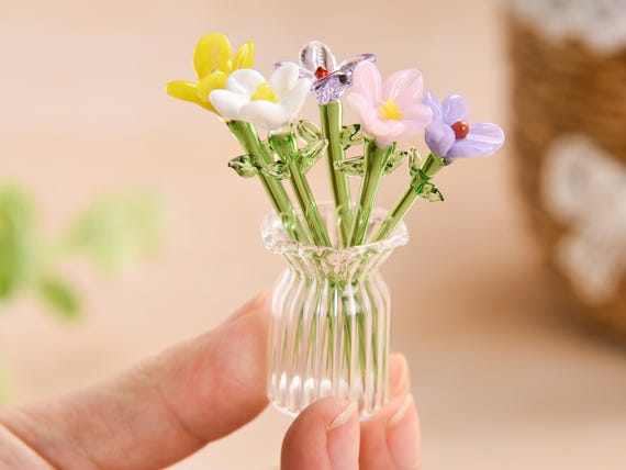 Tiny hand-blown glass birth month flower bouquets — each one a miniature botanical sculpture you can actually give with meaning.