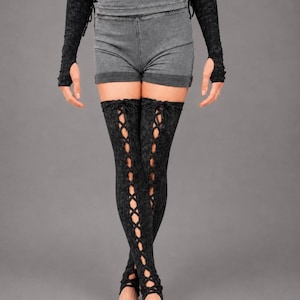 May include: A pair of black acid-wash thigh-high leg warmers featuring a vertical lace-up design with crisscross ties running down the front, paired with matching black acid-wash fingerless arm warmers that extend to the mid-forearm.